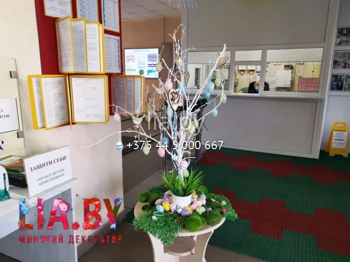 пасхальная композиция на столике в фойе, выполненная в виде белого дерева с ветвями на которых разноцветные пасхальные яйца на лентах