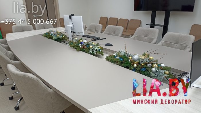 Украшение стола для переговоров еловыми ветками с декорациями.