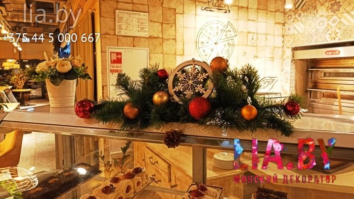 стойка с едой украшенная хвоей с жёлтыми и красными шарами и украшением в середине
