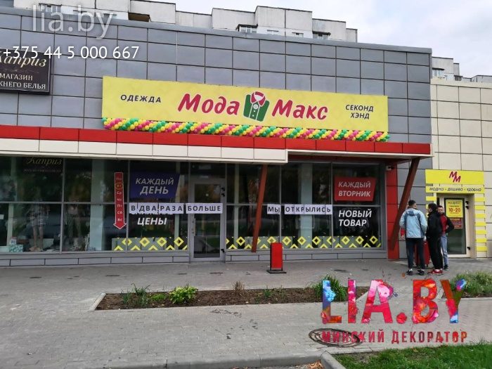 Гирлянда из небольших шаров желтого, зеленого и розового цвета на открытие магазина установлена на козырек под вывеской