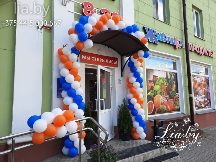 Украшение магазина Живинка гирляндой из шаров снаружи. Цвет шаров белый, голубой и оранжевый.