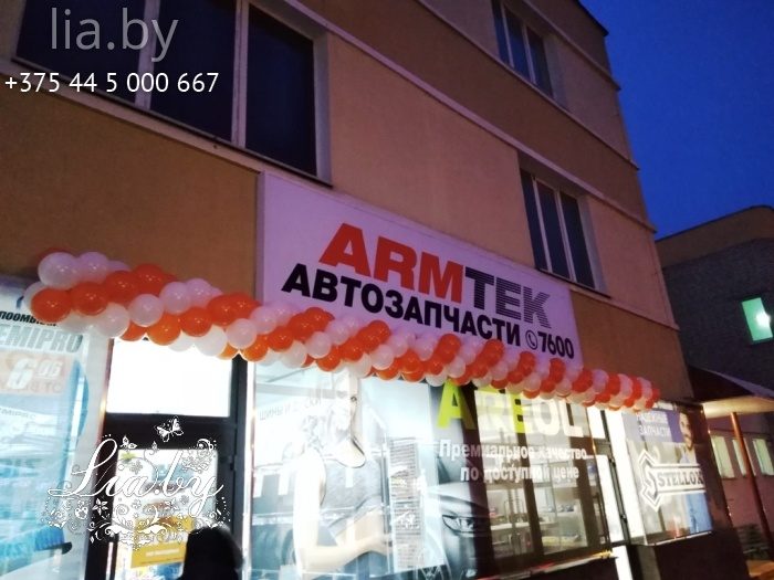 бело оранжевая гирлянда украшает козырек магазина автозапчастей