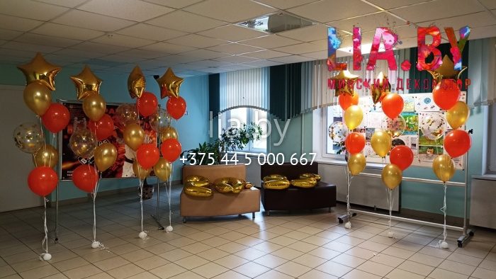 Украшение фойе школы фонтанами из шаров с гелием в красно-золотом цвете и с конфетти, а также фольгированные 2022 и звезды