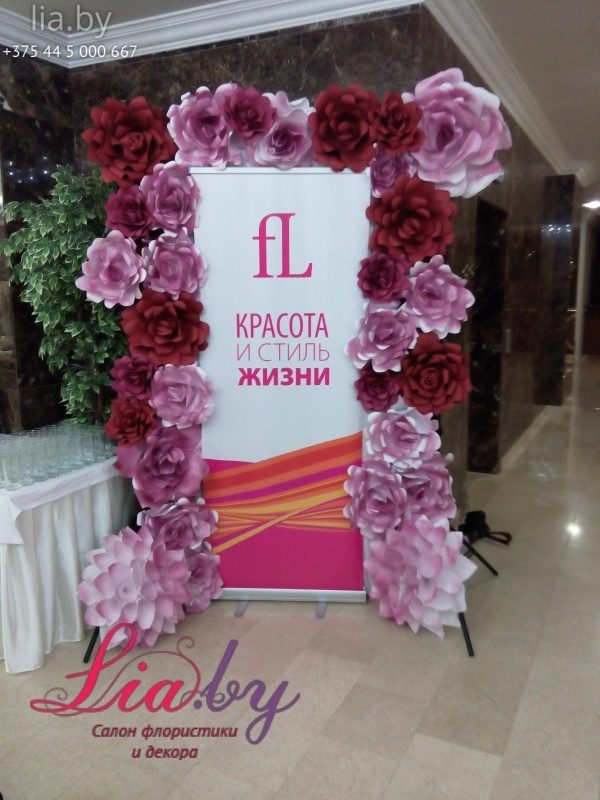 Украшение баннера компании цветами их бумаги на выставочном мероприятии