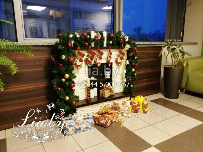 украшение холла в офисе рождественским камином с подарками