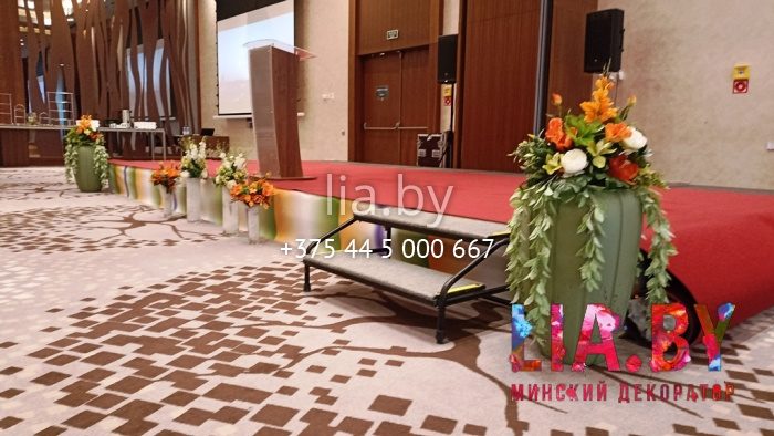 украшение сцены баннером на бампер (печать) и цветами в вазах оранжевого и белого цвета